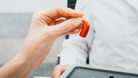 Holding Up A Red Hearing Aid